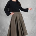 LOUISE flared skirt PDF sewing pattern: model posing in a khaki button-front midi skirt with a black long-sleeved top.