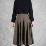 LOUISE midi skirt sewing pattern: back view of the khaki flared skirt worn with a black blouse.