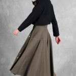 LOUISE circle midi skirt sewing pattern: side view of the khaki skirt swinging outward as the model walks.