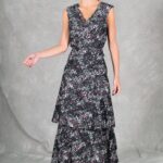 FOYS sewing pattern: fOYS long dress sewing pattern in black floral fabric, photographed as the model turns her head, with two soft skirt tiers beneath the fitted V-neck bodice.