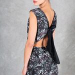 FOYS sewing pattern: close-up three-quarter rear view of the FOYS evening dress sewing pattern in black floral fabric, focusing on the open back and long black bow.