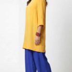 Loose-fit tunic sewing pattern MERVEILLE: three-quarter view, flowing yellow tunic with three-quarter sleeves