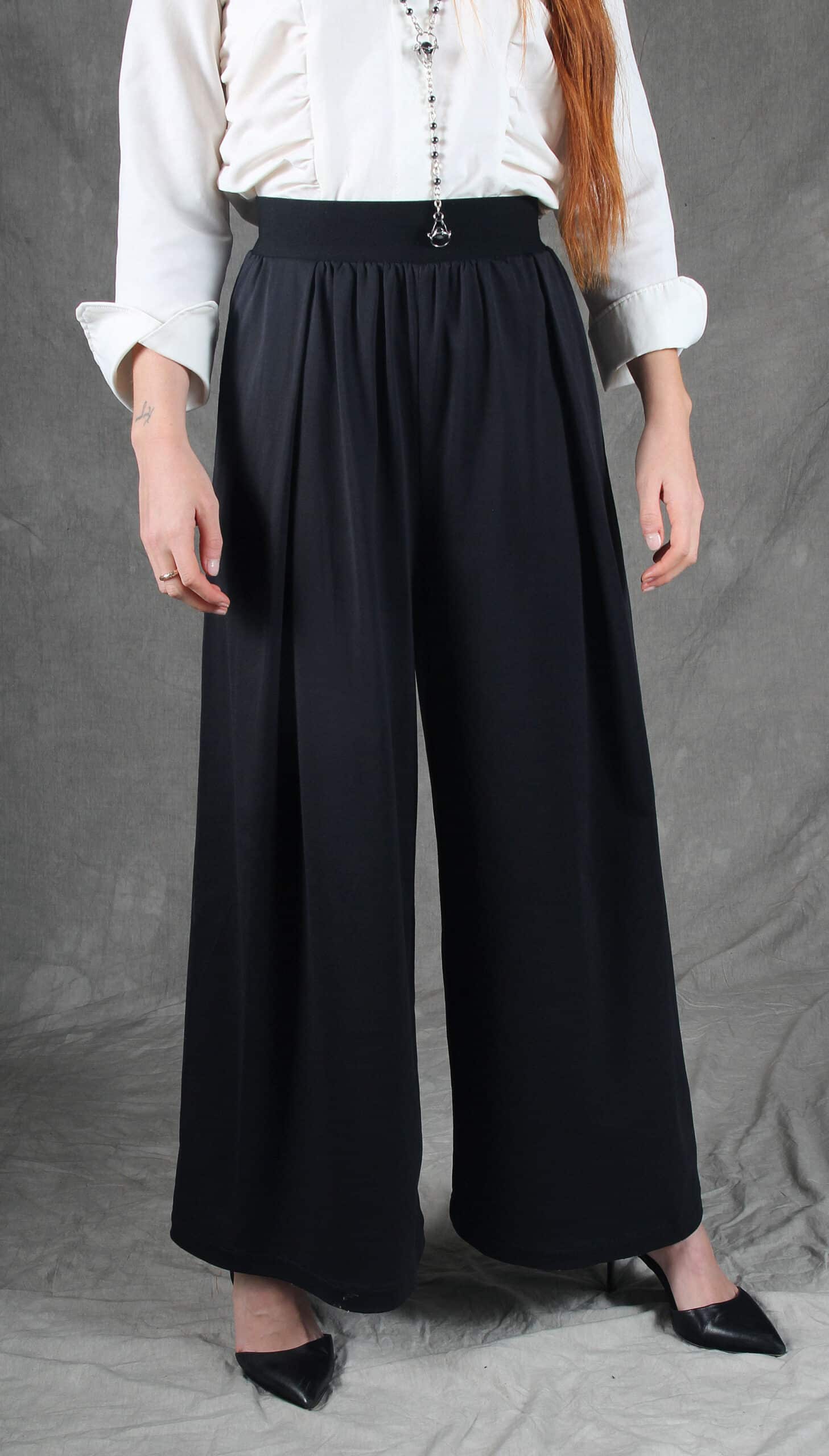 Model showcasing a pair of elegant wide-leg pants crafted with a wide-leg pants pattern, featuring a high-waisted fit and flowy design, paired with a sophisticated white blouse.