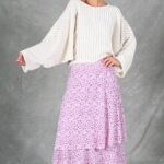 BOHEME boho maxi skirt sewing pattern with pink print, shown as the model poses with a hand on her hip to highlight the waist and side flounce.