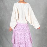 Rear view of the BOHEME maxi skirt sewing pattern in lilac-and-pink printed fabric, showing the flared lower skirt beneath a loose cream blouse.
