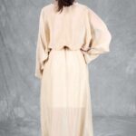Back view of the LOVY maxi dress sewing pattern in cream, showing the loose sleeves, cinched waist and flowing back skirt.