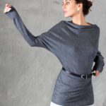A model wearing a long sleeve top crafted with the TWYS top pattern. The top features a bias-cut design, offering a flattering drape and a comfortable fit. Styled with a belt to accentuate the waist, the look is paired with a textured white skirt, showcasing the top's versatility for both casual and elegant occasions.