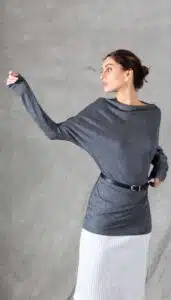 A model wearing a long sleeve top crafted with the TWYS top pattern. The top features a bias-cut design, offering a flattering drape and a comfortable fit. Styled with a belt to accentuate the waist, the look is paired with a textured white skirt, showcasing the top's versatility for both casual and elegant occasions.