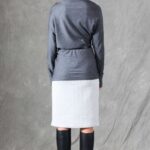 A model wearing a long sleeve top crafted with the TWYS top pattern. The top features a bias-cut design, offering a flattering drape and a comfortable fit. Styled with a belt to accentuate the waist, the look is paired with a textured white skirt, showcasing the top's versatility for both casual and elegant occasions.