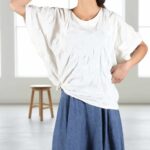 CALYS one-piece top sewing pattern illustrated in bright yellow, with front and back views plus an alternative front styling tied into a knot at the hip.