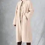 VIVIANE long women’s coat PDF pattern: beige button-front coat worn over a checked shirt against a grey backdrop.