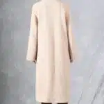 Back view of the long beige VIVIANE coat sewing pattern, showing the coat length and raglan-sleeve silhouette.