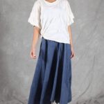 Front view of the CALYS easy blouse sewing pattern in white fabric, showing its round neckline, wide short sleeves and relaxed fit over a navy maxi skirt.