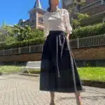 Model wearing a loose, three-quarter sleeve women's top crafted with a sewing pattern. The fabric is lightweight and semi-sheer, featuring a delicate floral pattern, paired with a long, voluminous black skirt for an elegant, flowing look.