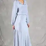 GIULIA sewing pattern: side-angle view of the GIULIA midi skirt sewing pattern in pale blue, revealing its softly flared hem as the model steps forward.