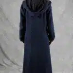 Modelo vistiendo un abrigo largo con capucha, confeccionado con un patrón de abrigo con capucha, que muestra un diseño semiajustado, con vuelo y cierre de botones.