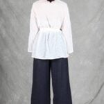 A woman is wearing a sheer white shirt with floral embroidery, crafted with a shirt sewing pattern.