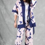 A person with long hair stands against a gray backdrop, wearing a white and blue kimono made with a kimono jacket pattern.