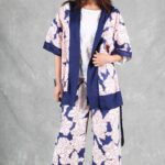 A person with long hair stands against a gray backdrop, wearing a white and blue kimono made with a kimono jacket pattern.