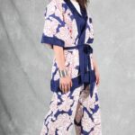A person with long hair stands against a gray backdrop, wearing a white and blue kimono made with a kimono jacket pattern.