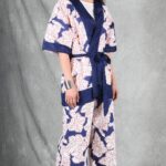 A person with long hair stands against a gray backdrop, wearing a white and blue kimono made with a kimono jacket pattern.