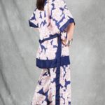 A person with long hair stands against a gray backdrop, wearing a white and blue kimono made with a kimono jacket pattern.