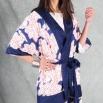 A person with long hair stands against a gray backdrop, wearing a white and blue kimono made with a kimono jacket pattern.