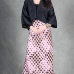 LORENA long bias-cut skirt sewing pattern: model standing in a pink spotted flowing skirt and oversized black top.