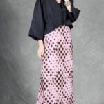 LORENA long bias-cut skirt sewing pattern: pink patterned skirt falling softly below the calves, worn with a black top.