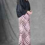 LORENA long skirt sewing pattern: angled side view of the pink spotted bias-cut skirt with a flowing hem.