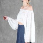 Model wearing a flowy summer top made from a summer top sewing pattern and a long skirt, . The top is an off-the-shoulder white lace design, paired with a blue maxi skirt.