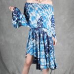 Model wearing a flowy summer top made from a summer top sewing pattern and a long skirt, . The top is an off-the-shoulder white lace design, paired with a blue maxi skirt.
