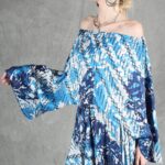 Model wearing a flowy summer top made from a summer top sewing pattern and a long skirt, . The top is an off-the-shoulder white lace design, paired with a blue maxi skirt.
