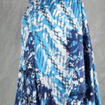 Model wearing a flowy summer top made from a summer top sewing pattern and a long skirt, . The top is an off-the-shoulder white lace design, paired with a blue maxi skirt.