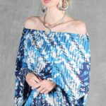 Model wearing a flowy summer top made from a summer top sewing pattern and a long skirt, . The top is an off-the-shoulder white lace design, paired with a blue maxi skirt.