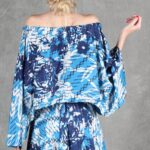 Model wearing a flowy summer top made from a summer top sewing pattern and a long skirt, . The top is an off-the-shoulder white lace design, paired with a blue maxi skirt.