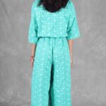 COLETTE relaxed jumpsuit sewing pattern: green one-piece garment with loose sleeves and flowing trousers.