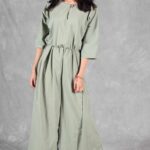 COLETTE green jumpsuit sewing pattern for women, with wide trouser legs and soft waist pleats.