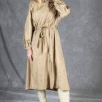 Full-length front view of the BLIZZARD beige trench raincoat sewing pattern, showing the waist belt, long sleeves and calf-length hem.