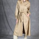 Beige BLIZZARD raincoat sewing pattern photographed from the front, with a loosely open coat front and self-fabric tie belt.