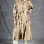 BLIZZARD long raincoat sewing pattern in beige, photographed at a slight angle to show the relaxed silhouette and belted waist.