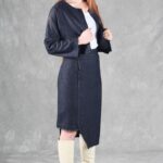 "Model wearing a denim jacket crafted with a cropped jacket pattern, featuring a minimalist design with a round neckline, long sleeves, and two blue buttons, paired with a high-waisted skirt.
