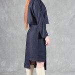 "Model wearing a denim jacket crafted with a cropped jacket pattern, featuring a minimalist design with a round neckline, long sleeves, and two blue buttons, paired with a high-waisted skirt.