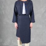 Front view of the JANYS pencil skirt sewing pattern, styled with an open navy cropped jacket over a white top and cream boots.