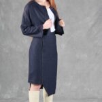 JANYS fitted pencil skirt sewing pattern in a three-quarter view, highlighting the asymmetrical hem with a cropped navy jacket.