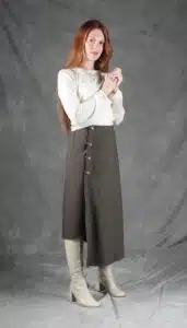 Model wearing an elegant wrap skirt crafted with a wrap skirt pattern, featuring a side button closure and a chic, flowing silhouette, paired with a light blouse and knee-high boots.