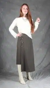 Model wearing an elegant wrap skirt crafted with a wrap skirt pattern, featuring a side button closure and a chic, flowing silhouette, paired with a light blouse and knee-high boots.