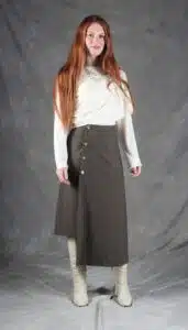 Model wearing an elegant wrap skirt crafted with a wrap skirt pattern, featuring a side button closure and a chic, flowing silhouette, paired with a light blouse and knee-high boots.
