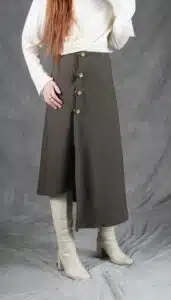 Model wearing an elegant wrap skirt crafted with a wrap skirt pattern, featuring a side button closure and a chic, flowing silhouette, paired with a light blouse and knee-high boots.