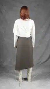 Model wearing an elegant wrap skirt crafted with a wrap skirt pattern, featuring a side button closure and a chic, flowing silhouette, paired with a light blouse and knee-high boots.